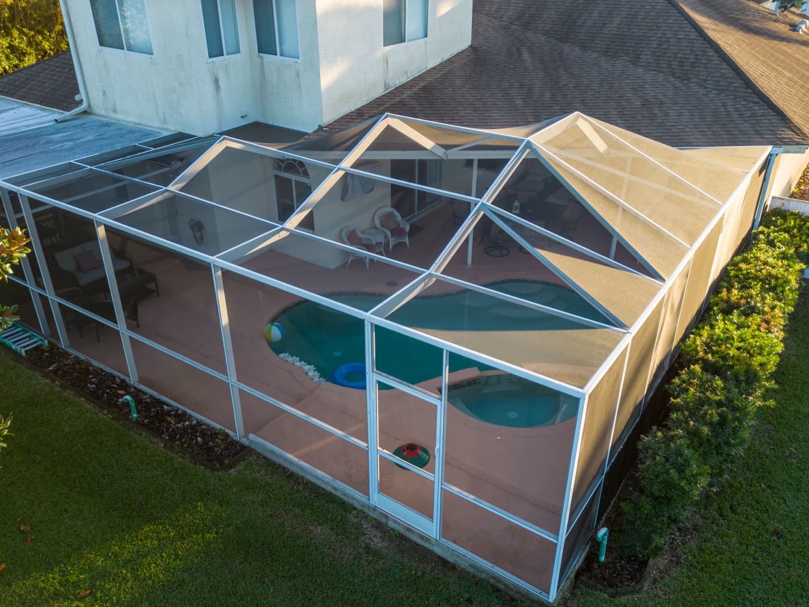 Screen pool enclosure with peaked gable roof sections, seen from above